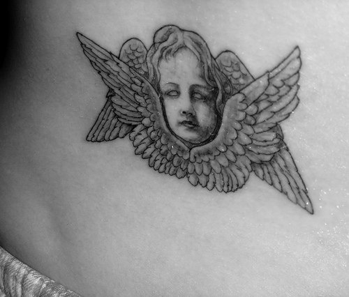 Il viso della bimba con le ali tatuato