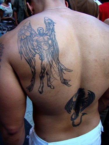 Ragazzo mezzo nudo con le ali tatuato sulla schiena