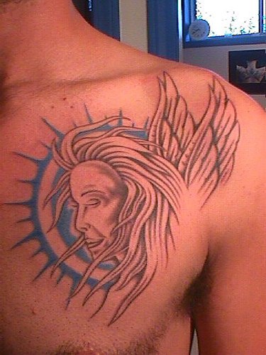 Profil angélique avec le soleil sur le fond tatouage sur la poitrine