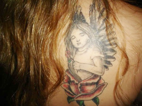 Tatuaje en la espalda Angelito en pétalos de rosa