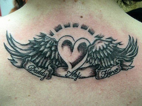 Le tatouage de cœur aillé avec une inscription le papa est non héro sur le dos