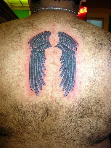 Black wings tattoo on hairy back