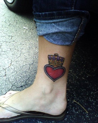 Une couronne sur le tatouage de cœur sur la cheville