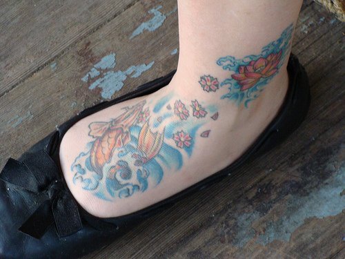 Tattoo von orangen Lilien  in der Knöchelgegend