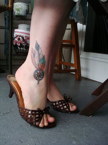 Colored plumelets ankle tattoo