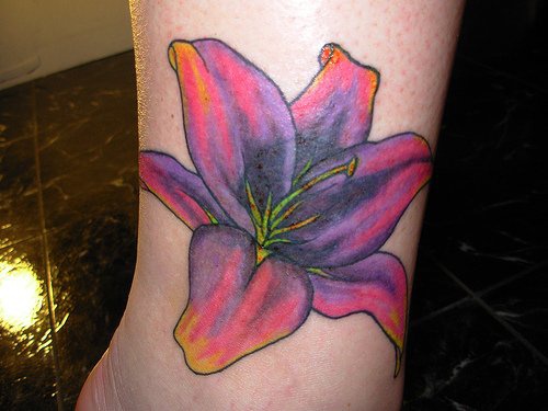 Tattoo von rosalila Lilie in der Knöchelgegend