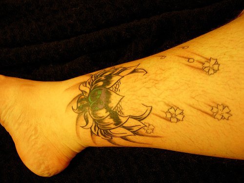 Heart decorated and falling flowers ankle tattoo