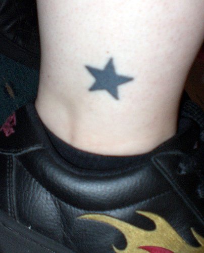 Tattoo von schwarzem Sternchen in der Knöchelgegend