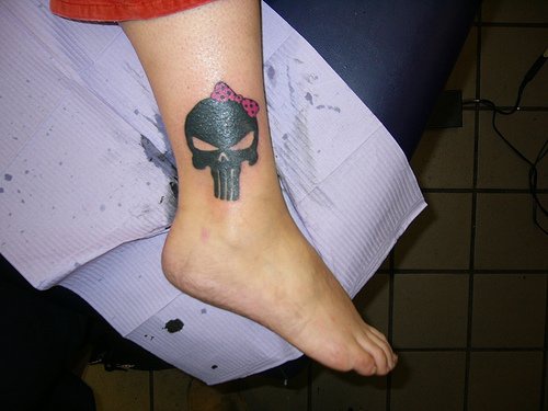 Skull with bow ankle tattoo