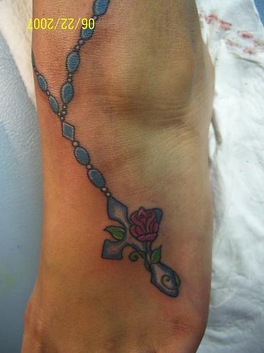 Une chaîne bleu avec le tatouage de croix et une fleur
