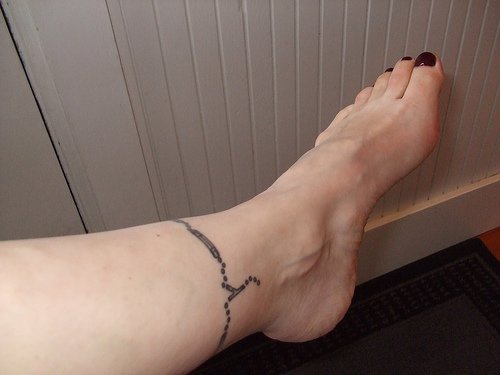 Tattoo von feinem Kettchen in der Knöchelgegend