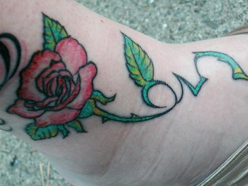 Tattoo von ausgestalteter Rosa in der Knöchelgegend
