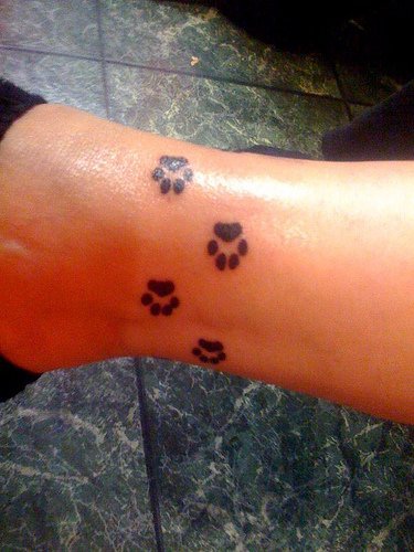 Tattoo von Hundespuren in der Knöchelgegend