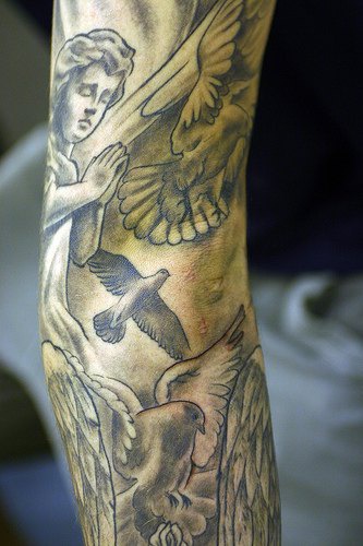 Angel and pigeons arm tattoo