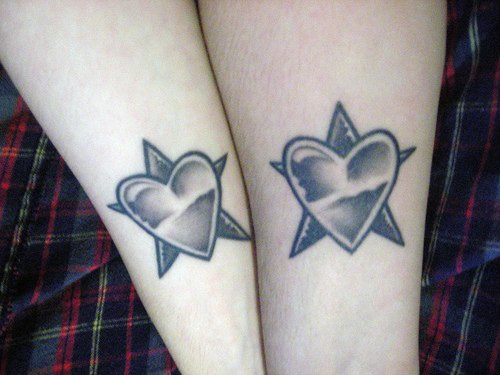 Two hearts on stars arm tattoo