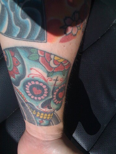 Skull in love arm tattoo