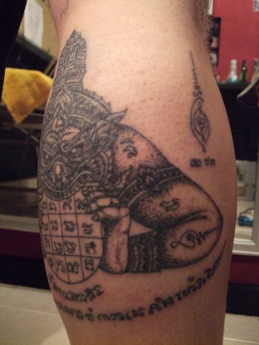 Tattoo von spielendem Monster am Arm