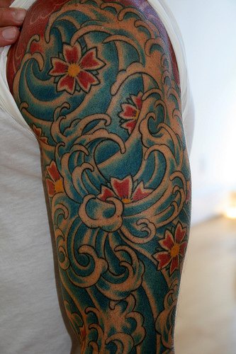 Flowers in waves arm tattoo