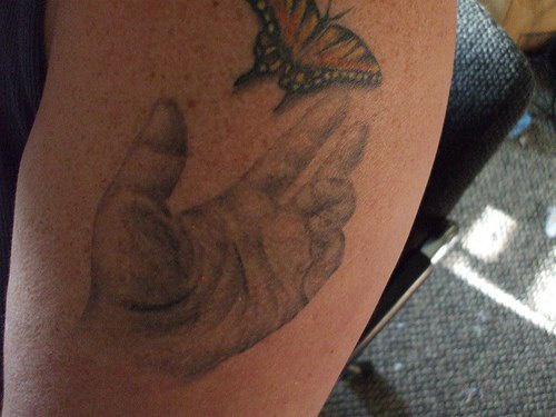Tatouage sur le bras avec un papillon