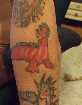 Un dinosaure le tatouage sur le bras