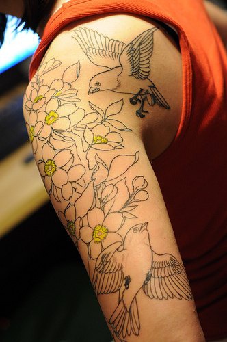 Tattoo von Vogel und Blumen am Arm