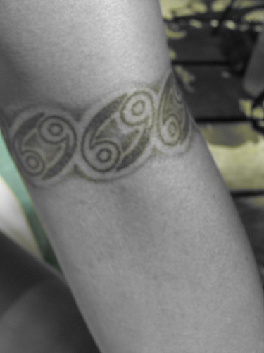 Sixty nine arm band tattoo