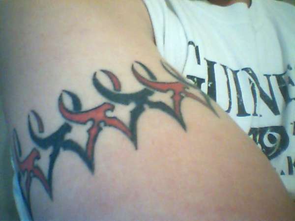 Tatuaje en el brazo con banda de logotipo terremoto rojo y negro.