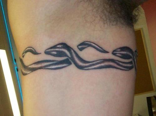 Tatuaje en el brazo con una banda de serpientes.