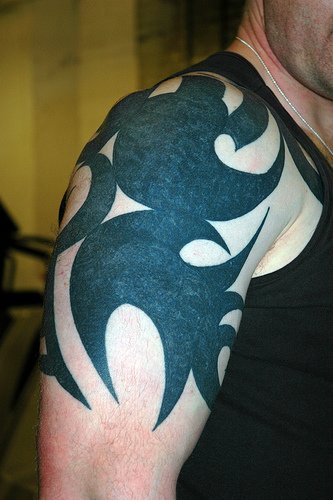 Tattoo mit schwarzem Ornament am Arm