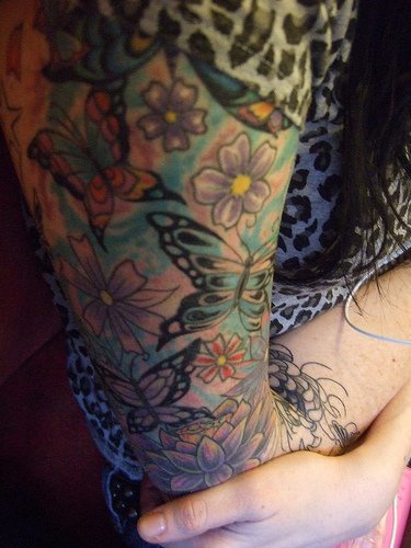 Butterflies and flowers arm tattoo
