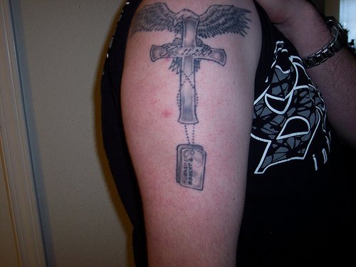 Aigle le tatouage sur le bras avec un croix