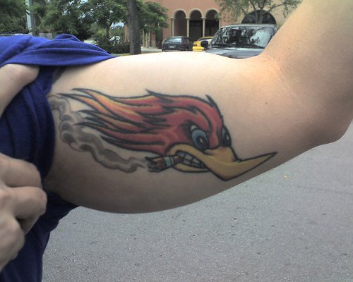 Tattoo von Specht mit einer Zigarette am Arm