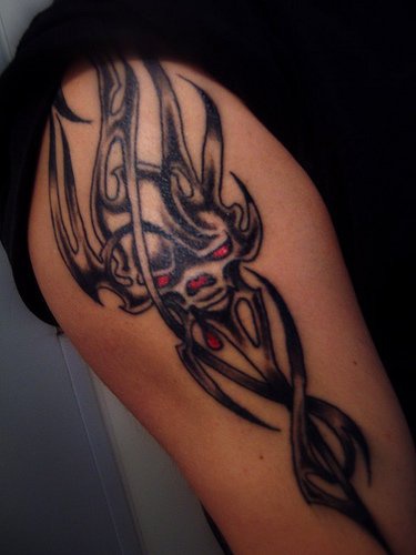 Tattoo von schön gestaltetem Monster am Arm