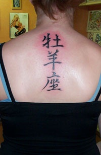 Tatuaje en la espalda de jeroglíficos chinos.