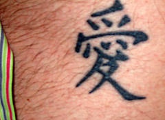 Tatuaje de jeroglíficos asiáticos en algunas partes del pelo del cuerpo.