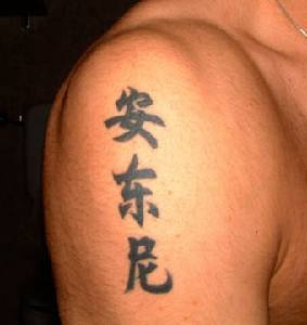 Le tatouage d&quothiéroglyphes asiatiques sur l"épaule