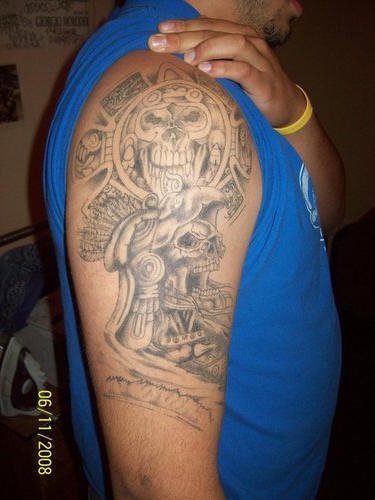 Tatuaje en el hombro de un cráneo estilizado azteca.
