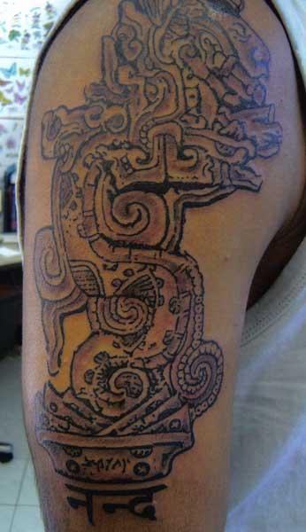 Le tatouage sur l'épaule d'un serpent aztèque en pierre