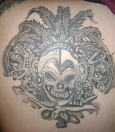Tatuaje de una calavera de estilo azteca con plumas.