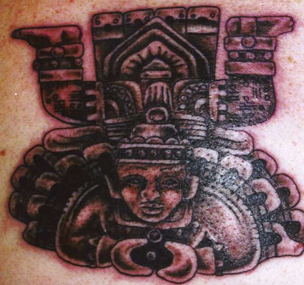 Tatuaje de una deidad azteca en piedra.