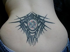 Tatuaggio in stile tribale sulla schiena della donna