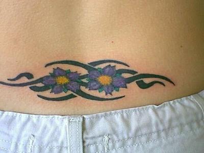 Tatuaje en color de tracería tribal con flores.