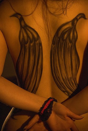 Interesante tatuaje de dos alas parecidas a dos aves en la espalda
