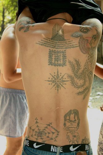Tattoo mit Text und Mann am oberen Rücken