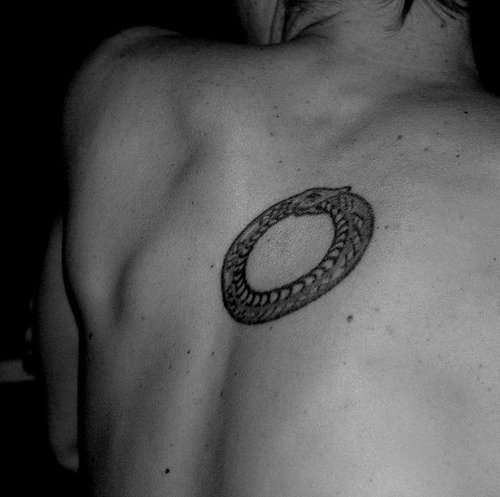 Snake tattoo stranded like a ring on upper back
