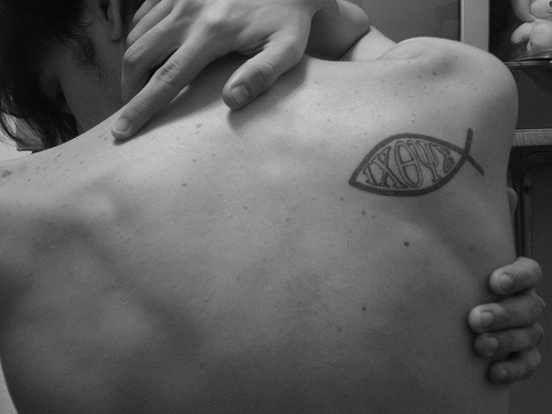 Le tatouage de haut du dos avec une image de poisson