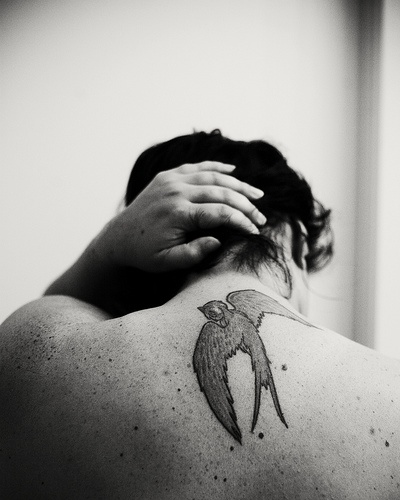 Le tatouage de haut du dos avec une hirondelle en noir et blanc