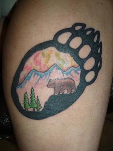 Tatuaje huella de oso con paisaje dentro