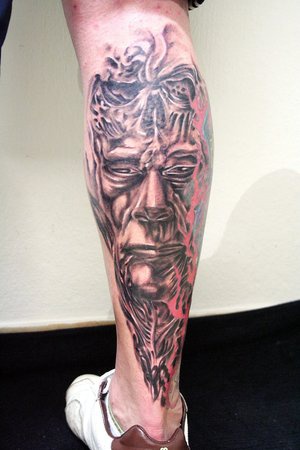 biomech vehhcio viso di uomo tatuaggio sulla gamba