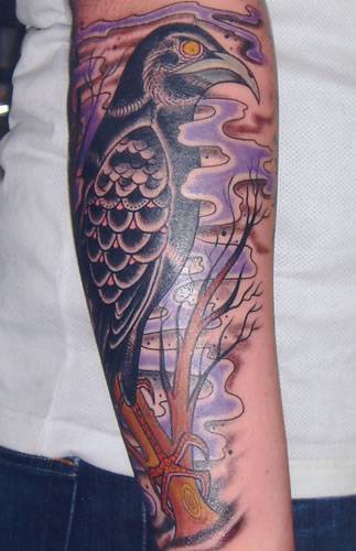 Tatuaje en el brazo, cuervo en la niebla